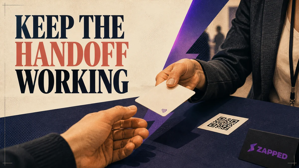 Recruiter handing an NFC business card to a candidate beside a visible QR fallback