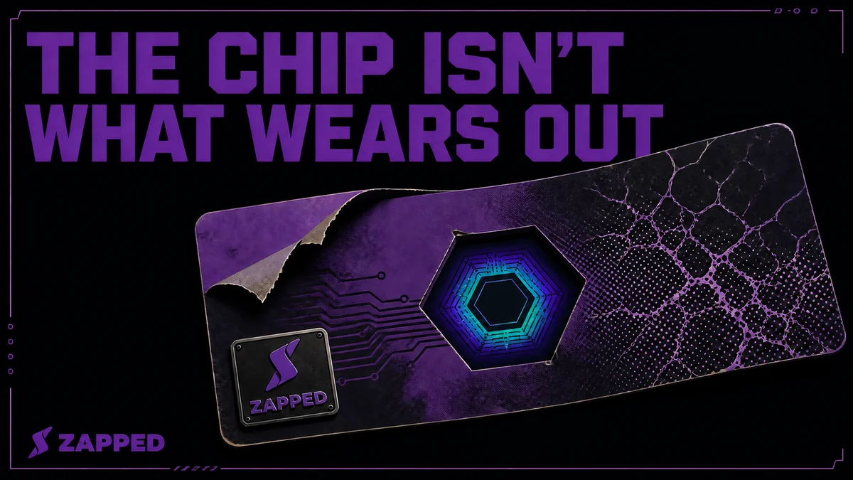 Editorial illustration of an NFC business card chip glowing steadily on a workbench while the plastic card body around it cracks and peels, showing the chip outlasting the card